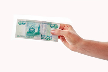 Female hand holding and giving a banknote of one thousand rubles isolated on white background. Russian currency, cash and pay concept
