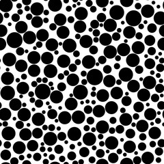Abstract seamless pattern of circles of different sizes in black and white colors