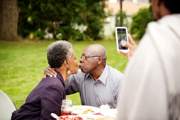 Senior couple kissing for photograph 