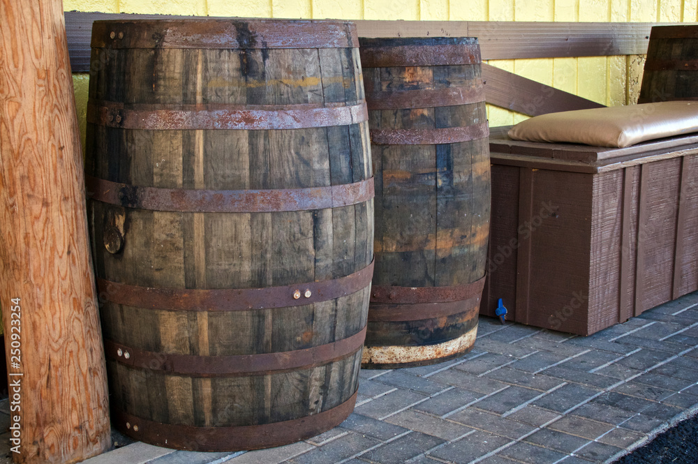 Wall mural two old antique wooden wine casks or beer barrels are outside against a wall.