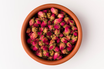 tea rose buds in a clay pot  isolated on white background, top view