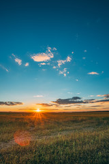Summer Sunset Sunrise Sky Above Countryside Rural Meadow Landscape. Sun Rising Above Rural Countryside Field