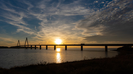 Fototapeta na wymiar highway bridge over water at sunset 