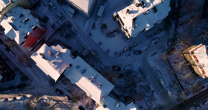 Urban view from flying above the houses and narrow streets on a winter day with snow