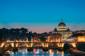 Fototapeta na wymiar Rome, Italy. Papal Basilica Of St. Peter In The Vatican And Aelian Bridge In Evening Night Illuminations