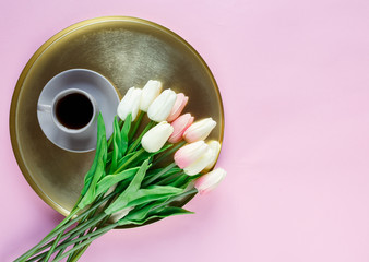 Golden tray plate with macaroons, tulips, coffee cup on pink background. Close up. Decoration for Mothers day, International Women day, festive background.