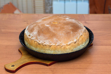 Kurnik, Russian pie with chicken, onion and potatoes. A traditional dish of dough lies on the table. © PAVEL GERASIMENKO