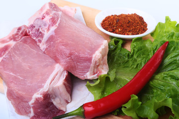 Raw pork chops with herbs and spices on cutting board. Ready for cooking.
