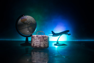 stack of traveling luggage in airport terminal and passenger plane flying over sky