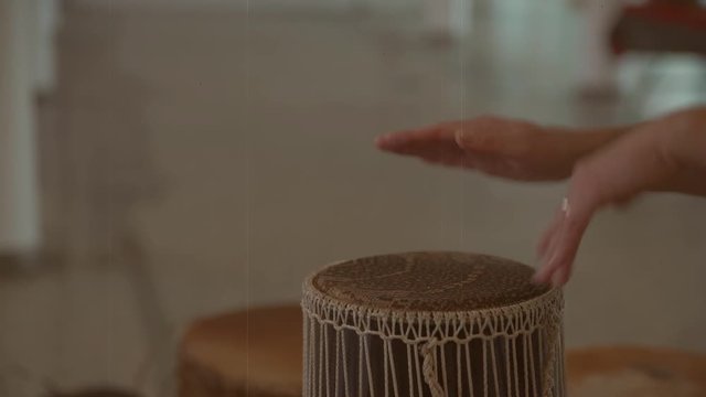 Women's hands beat on bongo musical motifs. Old-style video