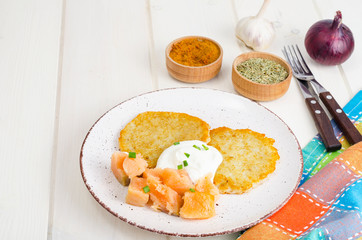 Potato pancakes with white sauce and smoked salmon