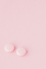 Pink pills on a pink background, copy space