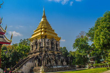 Fototapeta premium Old elephant chedi with golden top pagoda at Wat Chiang Man or Wat Chiang Mun, the oldest temple in Chiang Mai, Thailand, built in 1296 by King Mengrai in Lanna-style with elephant-shaped buttresses.