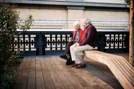 Senior couple laughing on bench 