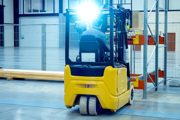 The forklift operator puts a pallet with boxes on the rack. Forklift places the goods in stock....
