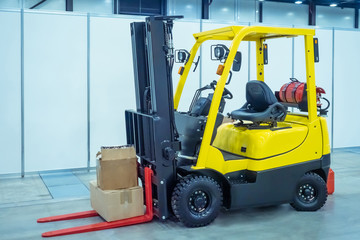 Forklift operator. Forklift in stock. Loader picks up boxes. Unloading goods. Warehousing. Warehouse storage. Logistics in stock.