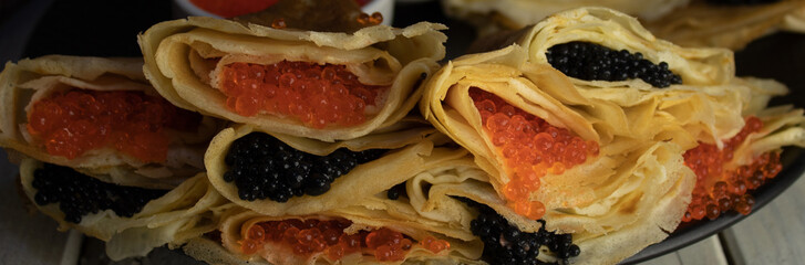 Pancakes stuffed with caviar close-up, mix