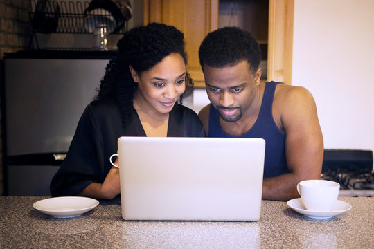 Couple watching laptop while drinking coffee 