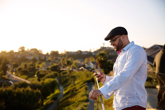Smiling man using mobile phone on patio 