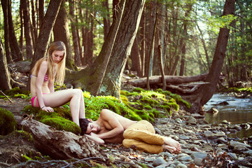 Young man and his girlfriend (16-17) relaxing by river 