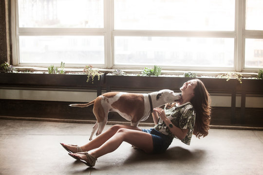 Young woman playing with dog 
