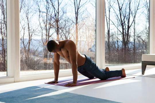 Young man exercising in living room 