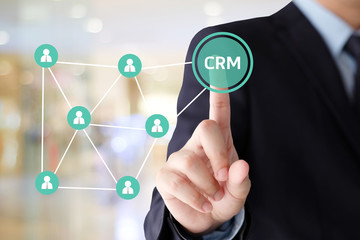 Businessman hand touch CRM, Customer Relationship Management, icon over blur background, success in business concept