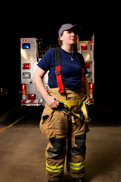 Female firefighter in front of fire engine 