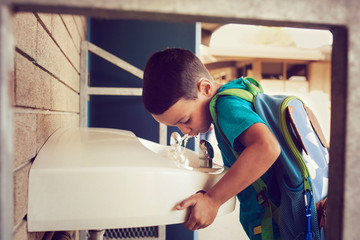 Boy drinking from water fountain 