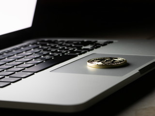 cryptocurrency bitcoin gold coin lying on a laptop.