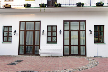 a city building with several doors, a long balcony and flowers in pots