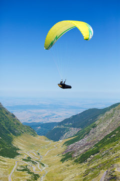 Man parachuting over valley 