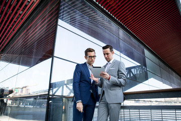 Two businessmen looking at digital tablet 