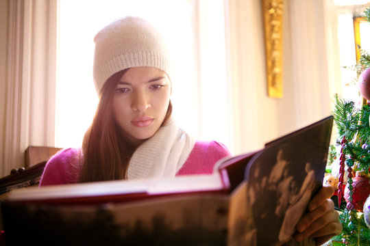 Woman reading book in winter cap 