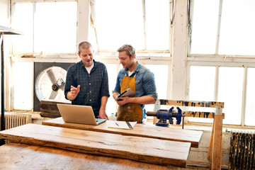 Mid adult men working in carpentry workshop 