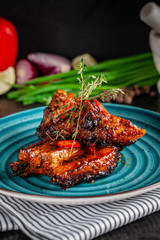 American cuisine. Grilled marinated pork ribs on a blue plate with shrimp and spicy chili in barbecue sauce. Background image. copy space