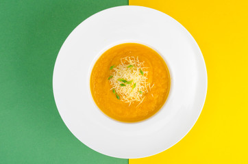 White plate with vegetable puree on bright background.