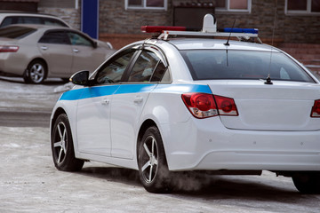 white police car with a blue stripe on board