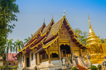 Naklejka premium Lanna style Buddhist church at Wat Phra Singh(Temple of the Lion Buddha) with blue sky background. Wat Phra Singh is an important Buddhist monastery and temple on the west side of Chiang Mai, Thailand