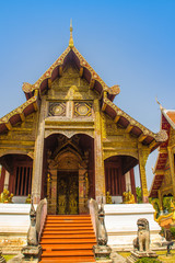 Fototapeta premium Lanna style Buddhist church at Wat Phra Singh(Temple of the Lion Buddha) with blue sky background. Wat Phra Singh is an important Buddhist monastery and temple on the west side of Chiang Mai, Thailand