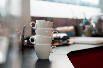 white coffee mugs stacked in mini cafe