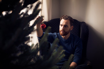 Young man hanging christmas ornament 