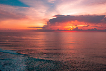 Fototapeta na wymiar amazing scarlet sunset wuth a big clouds on beautiful tropical Bali beach