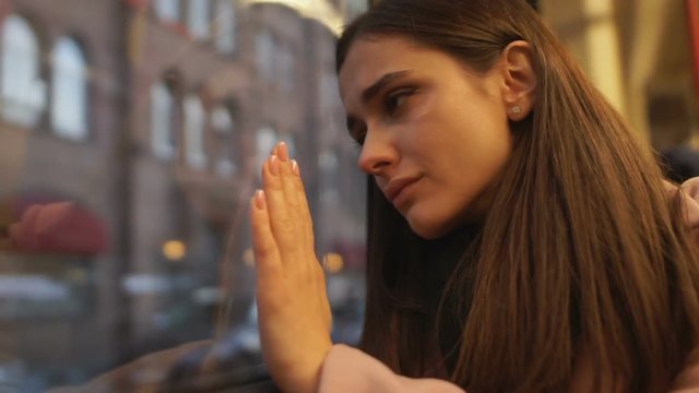 Depressed girl sitting in bus, leaving country and saying goodbye to hometown