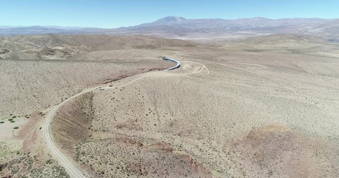 Aerial drone scene of train ridding at desertic mountainous landscape. Train of the clouds, tren de las nubes, San Antonio de los Cobres, Salta, Argentina. Touristic and recreational ride.