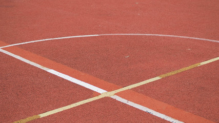 An empty of outdoor colorful basketball court in hongkong. Pole aerial image including of pavement crack, red key, yellow lines. health concept