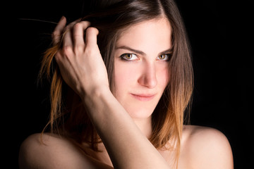 Naklejka premium Modella con mani tra i capelli su sfondo nero