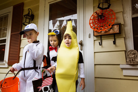 Children (4-5) wearing costumes collecting candy on halloween 