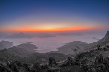 Obraz premium sunrise at Doi Pha Tang, beautiful mountain view morning panorama 180 degree of top hill around with sea of mist with yellow sun light and cloudy sky background, Chiang Rai, Thailand.