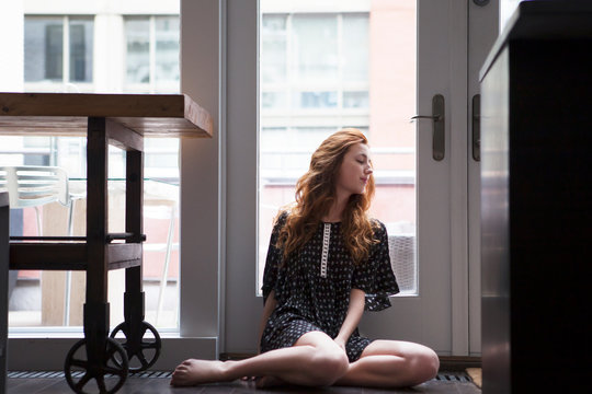 Young woman looking through window 